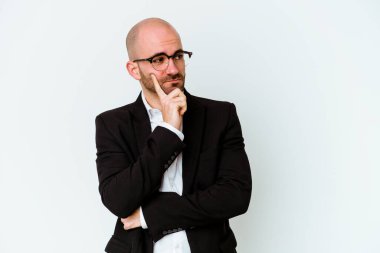 Genç, beyaz, kel bir adam mavi arka planda izole edilmiş. Bir strateji planlıyor, bir iş yolu düşünüyor..