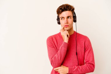 Renkli arka planda poz veren beyaz bir genç. 