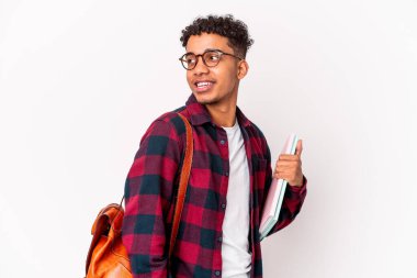 Genç Afro-Amerikalı kıvırcık erkek kitap tutuyor, gülümsüyor ve keyifli görünüyor..