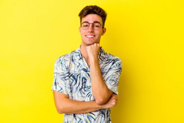 Renkli arka planda poz veren beyaz bir genç. 