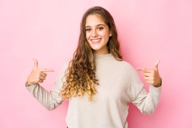 Genç beyaz kadın parmaklarıyla aşağı işaret ediyor, pozitif duygu..