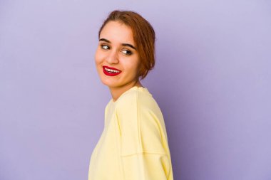 Genç Arap melez kadın gülümseyen, neşeli ve cana yakın bir şekilde yana bakıyor..