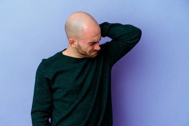 Mor arka planda izole genç beyaz adam stresten dolayı boyun ağrısı çekiyor, masaj yapıyor ve ona eliyle dokunuyor..