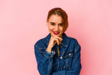 Genç Arap melez kadın gülümsüyor mutlu ve kendinden emin, elleriyle çenesine dokunuyor..