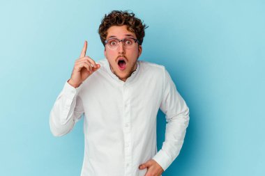 Kafkasyalı genç bir iş adamı mavi arka planda izole edilmiş. Bir fikri, ilham verici bir fikri var..