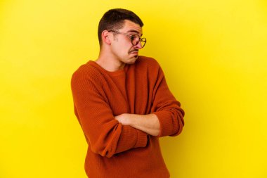 Sarı arka planda izole edilmiş genç beyaz adam tekrarlanan bir görevden bıktı..