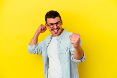 Sarı arka planda izole edilmiş genç beyaz adam dans ediyor ve eğleniyor..