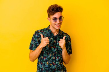 Renkli arka planda poz veren beyaz bir genç. 