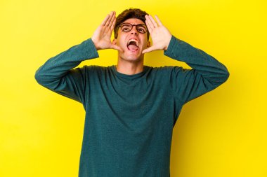 Renkli arka planda poz veren beyaz bir genç. 