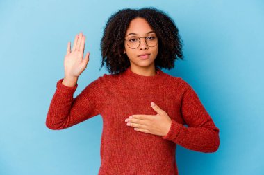 Genç Afro-Amerikan melez kadın tek başına yemin ediyor, elini göğsüne koyuyor..