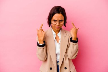 Pembe arka planda izole edilmiş genç iş kadını bir göreve odaklanmış, parmaklarını işaret ediyor..