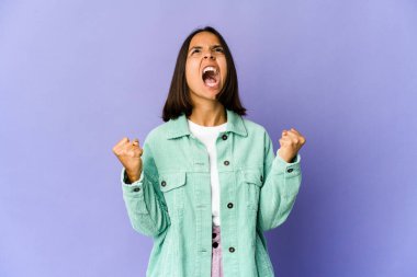 Genç melez kadın zaferden sonra yumruğunu kaldırıyor, kazanan konsept.