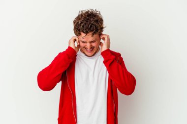 Beyaz arka planda izole edilmiş genç beyaz bir adam parmaklarıyla kulaklarını kapatıyor, gürültülü bir ortam yüzünden stresli ve çaresiz..