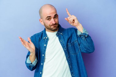 Mor arka planda izole edilmiş beyaz, kel bir adam elinde bir ürün tutuyor..