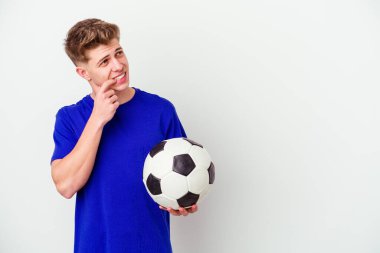 Futbol oynayan beyaz bir adam arka planda izole edilmiş rahat bir şekilde fotokopi odasına bakan bir şey düşünüyor..