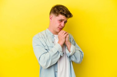 Sarı arka planda izole edilmiş genç beyaz adam korkmuş ve korkmuş..