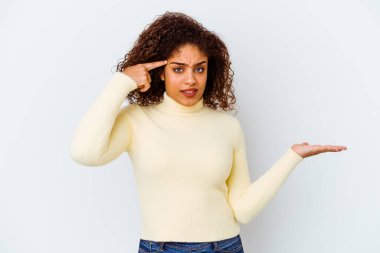 Beyaz arka planda izole edilmiş genç Afrikalı Amerikalı kadın elinde bir ürün tutuyor ve.