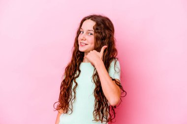 Pembe arka planda izole edilmiş küçük beyaz kız parmaklarıyla bir cep telefonu hareketi gösteriyor..