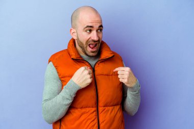 Mor arka planda izole edilmiş beyaz saçlı genç adam parmağını göstererek şaşırdı, geniş bir gülümsemeyle..