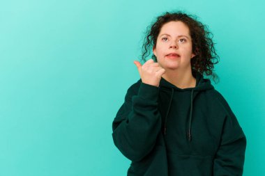 Down sendromlu bir kadın başparmağı uzakta, gülerek ve kaygısız bir şekilde izole edilmiş..