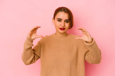 Genç Arap melez kadın elinde avuç içi bir şeyle kameraya sunuyor..