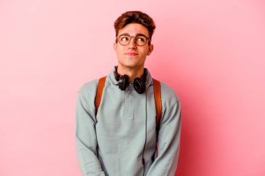 Renkli arka planda poz veren beyaz bir genç. 