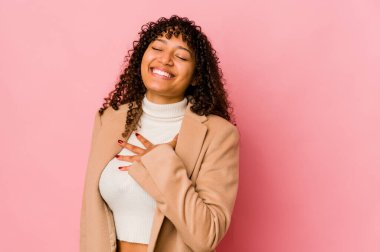 Genç Afrikalı Afro-Amerikan kadın yalnız kahkahaları göğsüne bastırıyor..