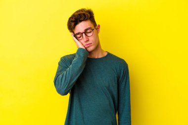 Renkli arka planda poz veren beyaz bir genç. 