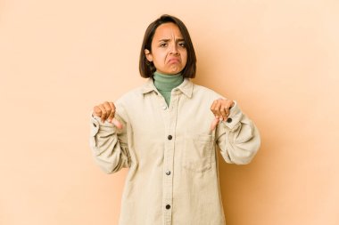 Genç İspanyol kadın kendini izole edip baş parmağını aşağı gösteriyor, hayal kırıklığı konsepti..