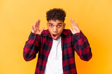 Genç Afro-Amerikalı kıvırcık adam Mor renkte izole edilmiş şaşırmış ve şok olmuş.