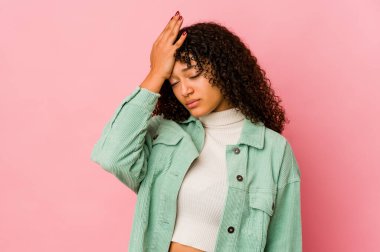 Genç Afrikalı Amerikalı afro kadın yorgun ve uykulu bir şekilde elini başının üstüne koyuyor..