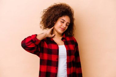Genç Afrikalı Amerikalı kadın bej arka planda izole edilmiş. Stres yüzünden boynu ağrıyor, masaj yapıyor ve elle dokunuyor..