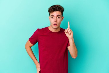 Renkli arka planda poz veren beyaz bir genç. 