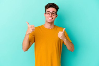 Renkli arka planda poz veren beyaz bir genç. 