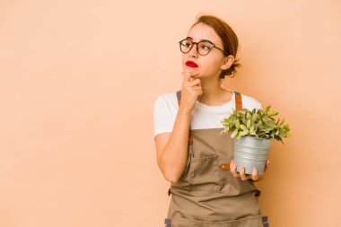 Sıska Arap bahçıvan kadın şüpheli ve şüpheci bir ifadeyle yana bakıyor..