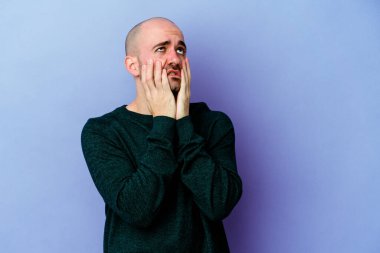 Mor arka planda, ağlayan ve sızlanan genç, beyaz kel bir adam var..