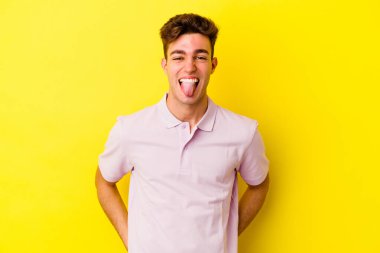 Renkli arka planda poz veren beyaz bir genç. 