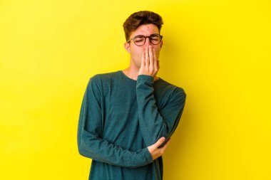 Renkli arka planda poz veren beyaz bir genç. 