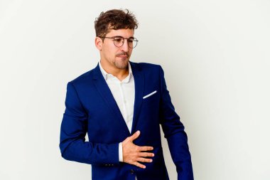 Beyaz arka planda soyutlanmış beyaz iş adamı karnına dokunuyor, nazikçe gülümsüyor, yemek yiyor ve tatmin oluyor..