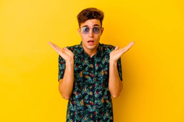 Renkli arka planda poz veren beyaz bir genç. 