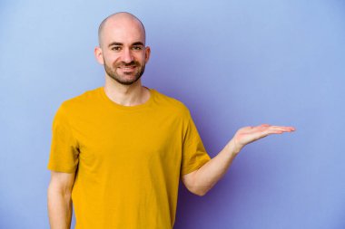 Mor arka planda izole edilmiş beyaz kel bir adam bir avuç içinde fotokopi alanı ve belinde bir el daha gösteriyor..