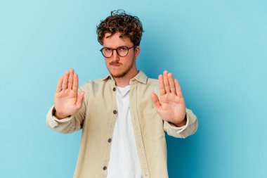 Mavi arka planda gözlüklü genç beyaz adam elini uzatıp dur işareti göstererek seni engelliyor..
