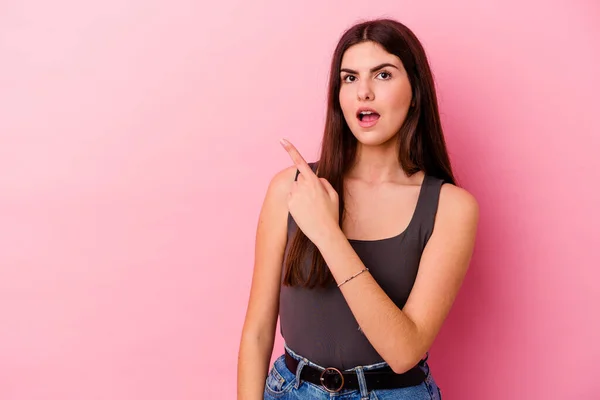 Jovem Caucasiana Isolada Sobre Fundo Rosa Apontando Para Lado — Fotografia de Stock