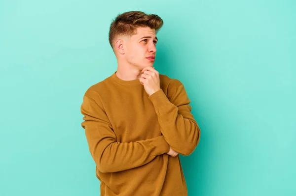 Joven Hombre Caucásico Aislado Sobre Fondo Azul Pensando Mirando Hacia — Foto de Stock