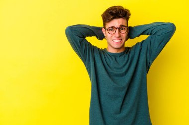 Renkli arka planda poz veren beyaz bir genç. 