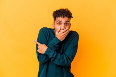 Genç Afro-Amerikalı kıvırcık adam, tek başına mor tarafa bakıyor.