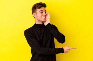 Renkli arka planda poz veren beyaz bir genç. 