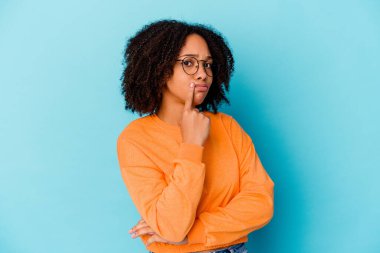 Genç Afro-Amerikan melez kadın kameraya bakıp alaycı bir ifadeyle kendini soyutlamış..