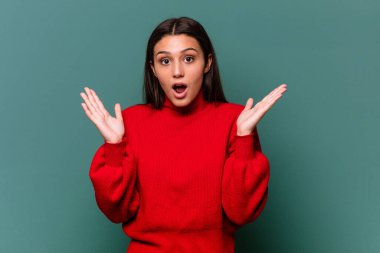 Mavi arka planda yalnız yaşayan genç Hintli kadın şaşırdı ve şok oldu..