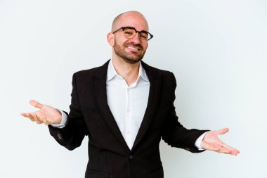 Genç, beyaz, kel bir adam mavi arka planda izole edilmiş ve hoş bir ifade sergiliyor..